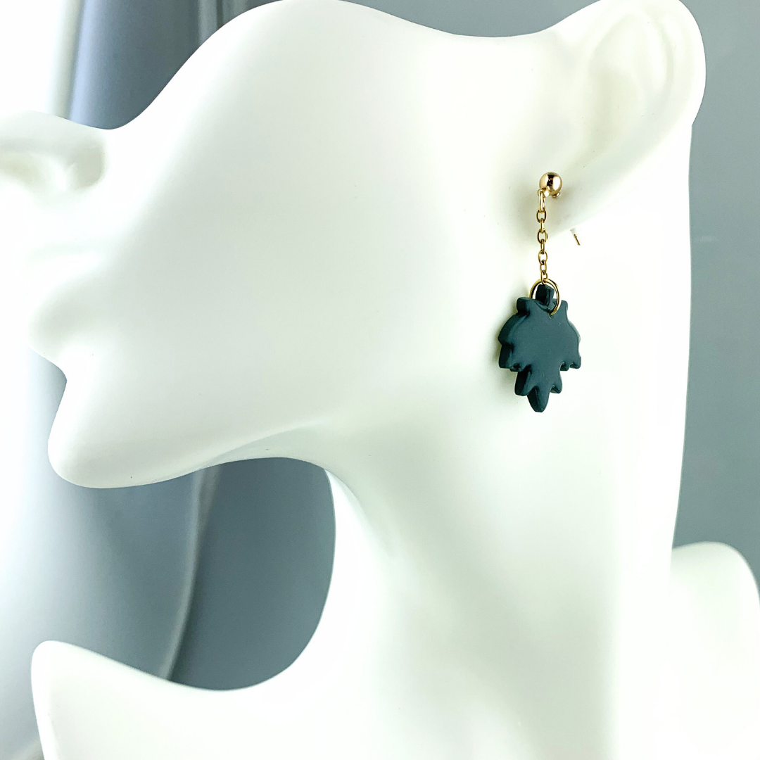 Gullfargede polymerleire øredobber med hengende grønt blad