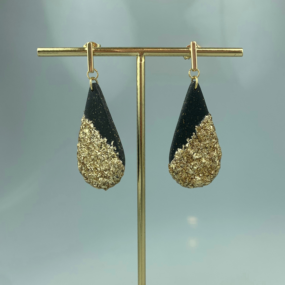 Gullfargede øredobber med stor sort dråpe med gullblad