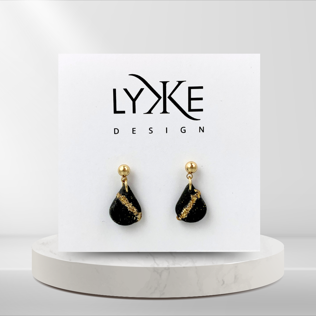 Gullfargede øredobber med liten dråpe med gullblad-stripe