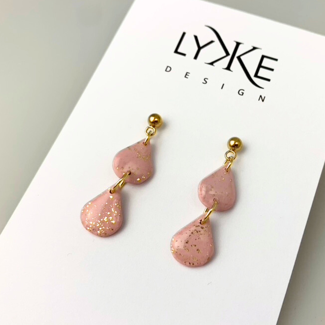 Gullfargede øredobber med to rosa dråper