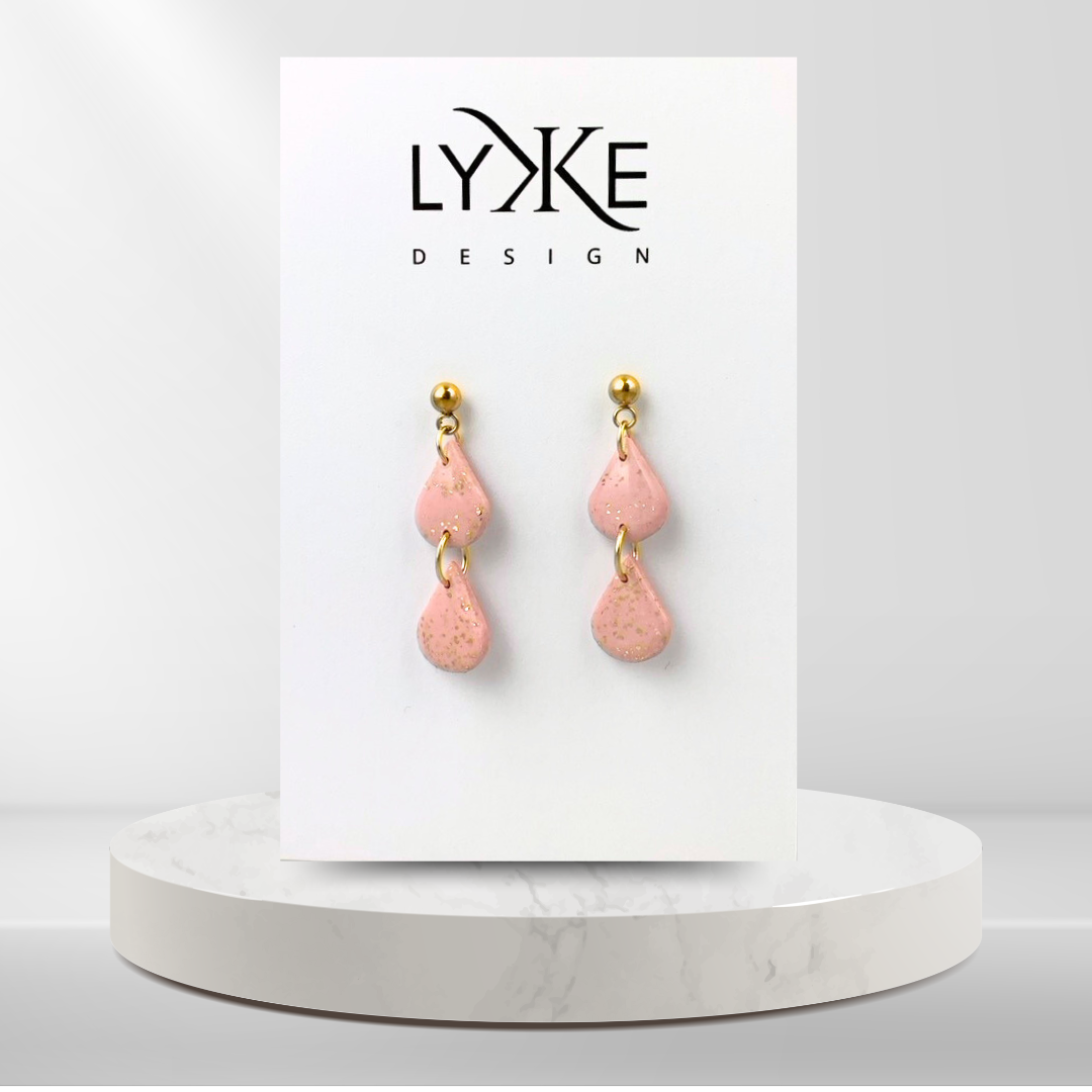 Gullfargede øredobber med to rosa dråper