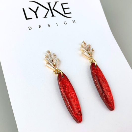 Gullfargede øredobber med glitrende rød dåpe og zirkonia stener