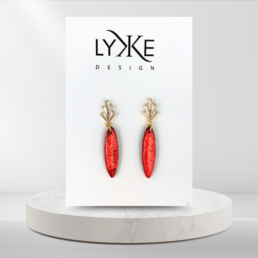 Gullfargede øredobber med glitrende rød dåpe og zirkonia stener