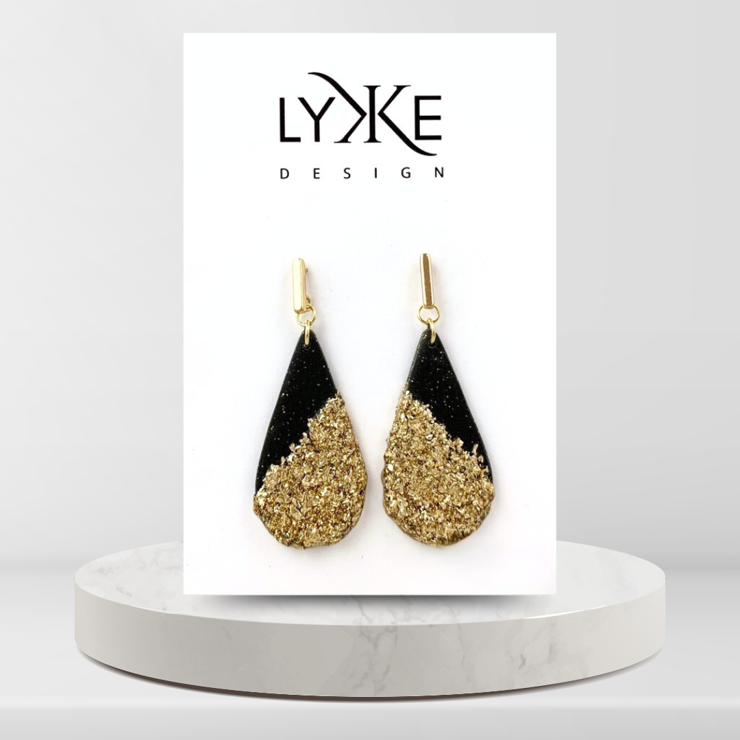 Gullfargede øredobber med stor sort dråpe med gullblad