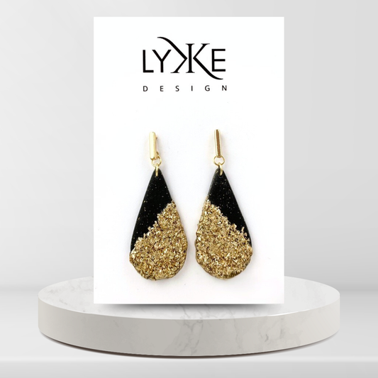 Gullfargede øredobber med stor sort dråpe med gullblad