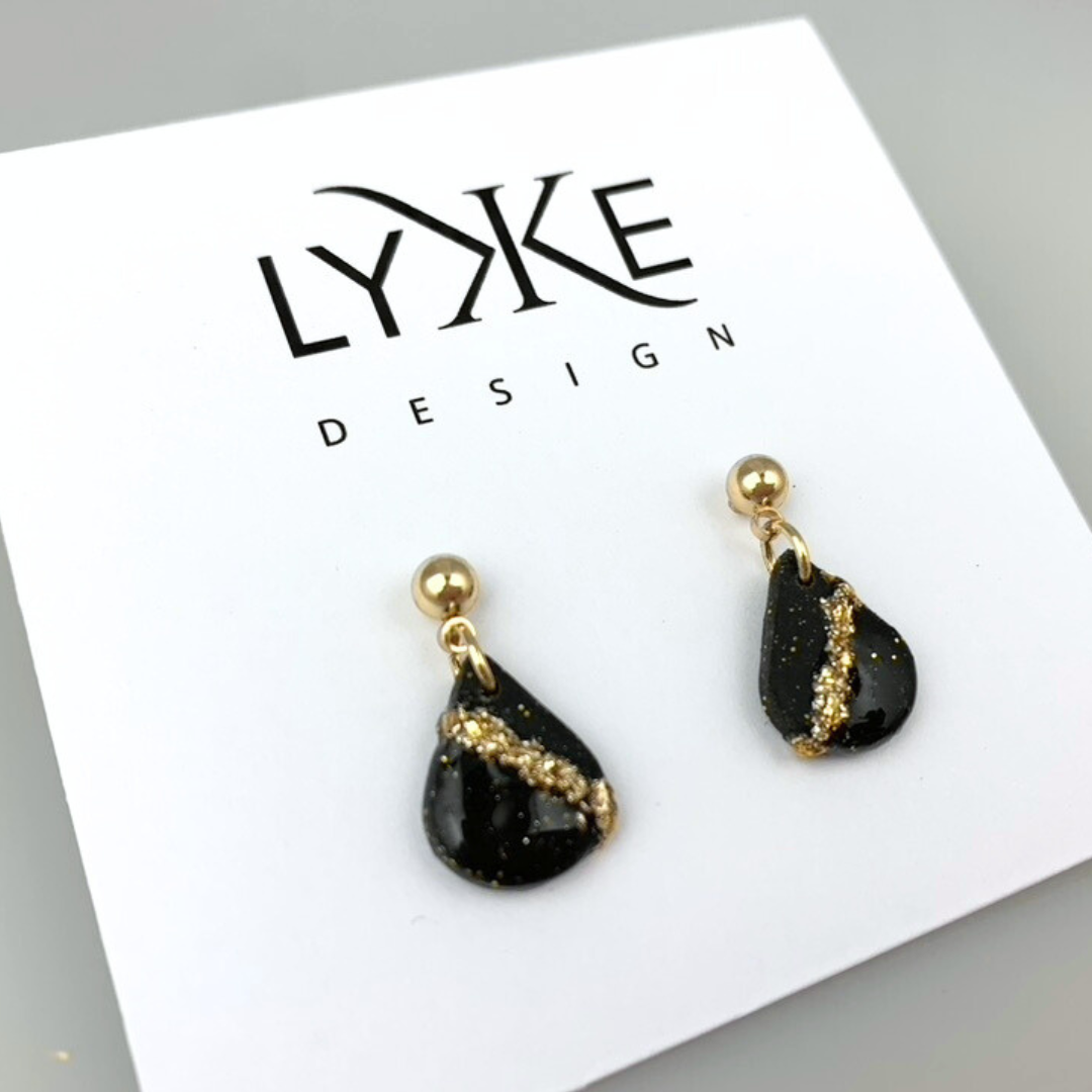 Gullfargede øredobber med liten dråpe med gullblad-stripe