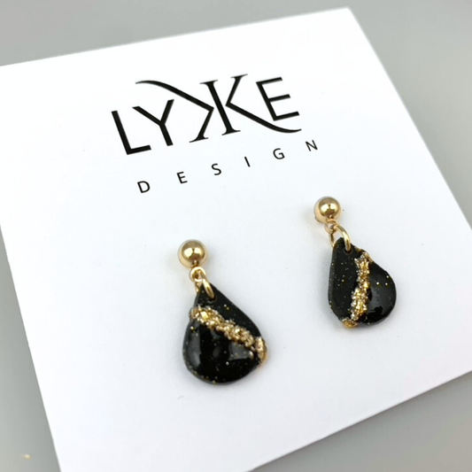 Gullfargede øredobber med liten dråpe med gullblad-stripe