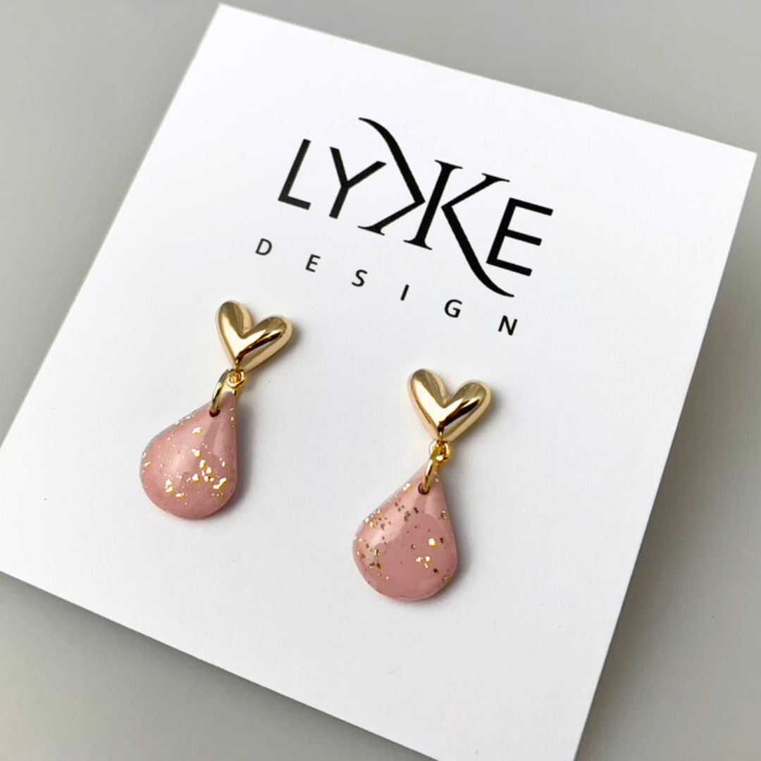 Gullfargede hjerte-øredobber med rosa dråpe